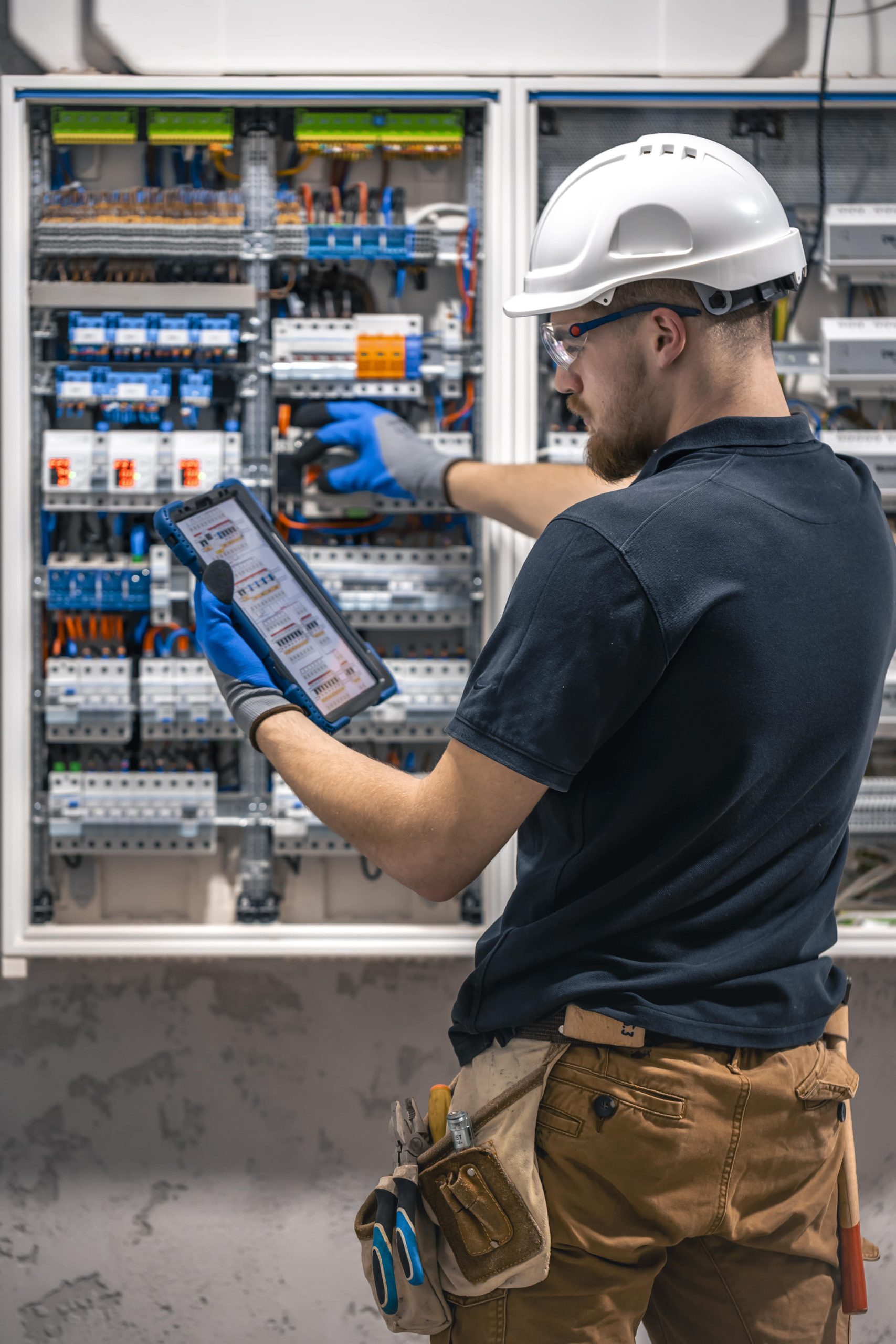 electrical technician working switchboard with fuses uses tablet 1 min scaled