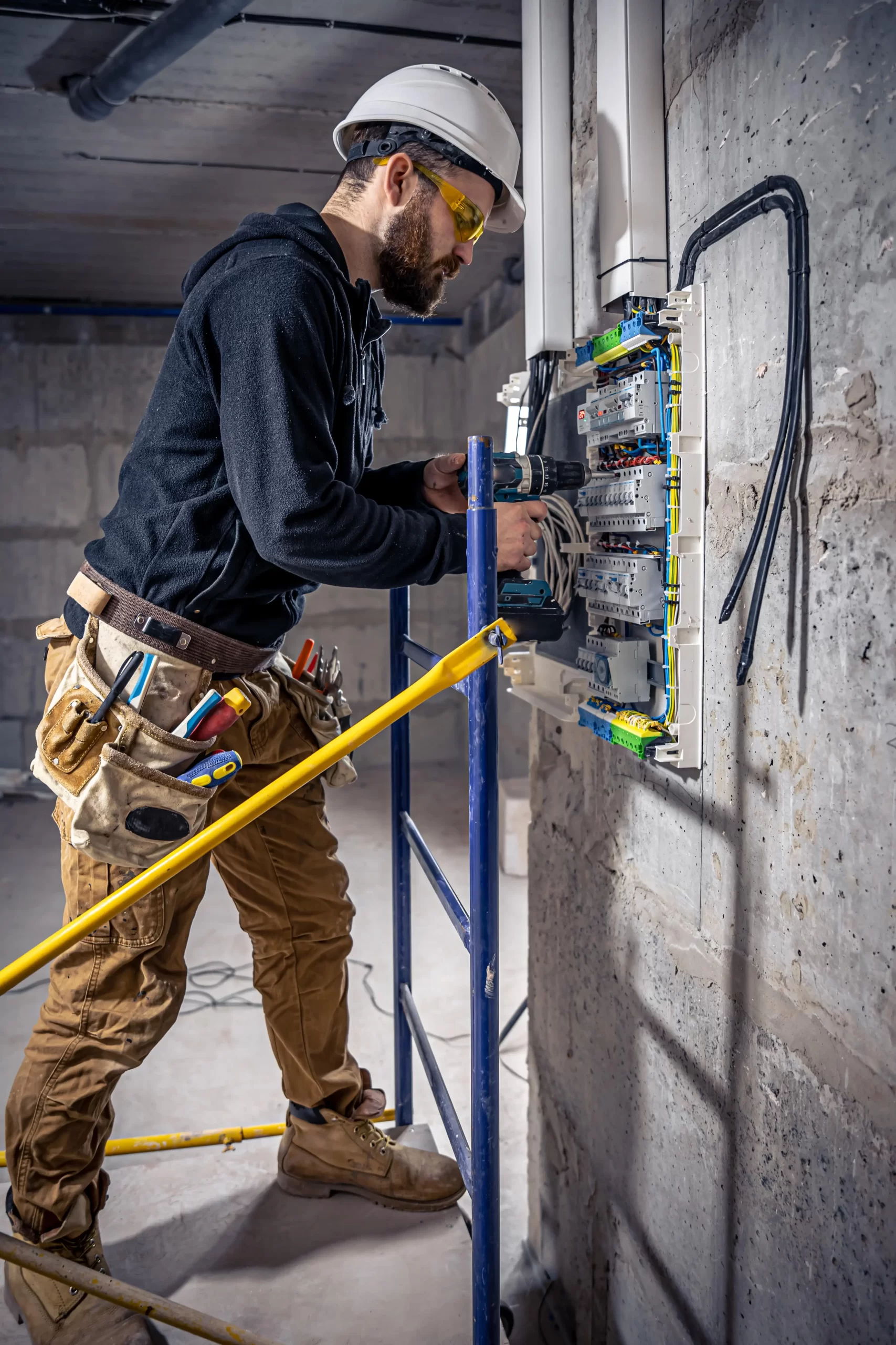 male electrician works switchboard with electrical connecting cable 1 min scaled