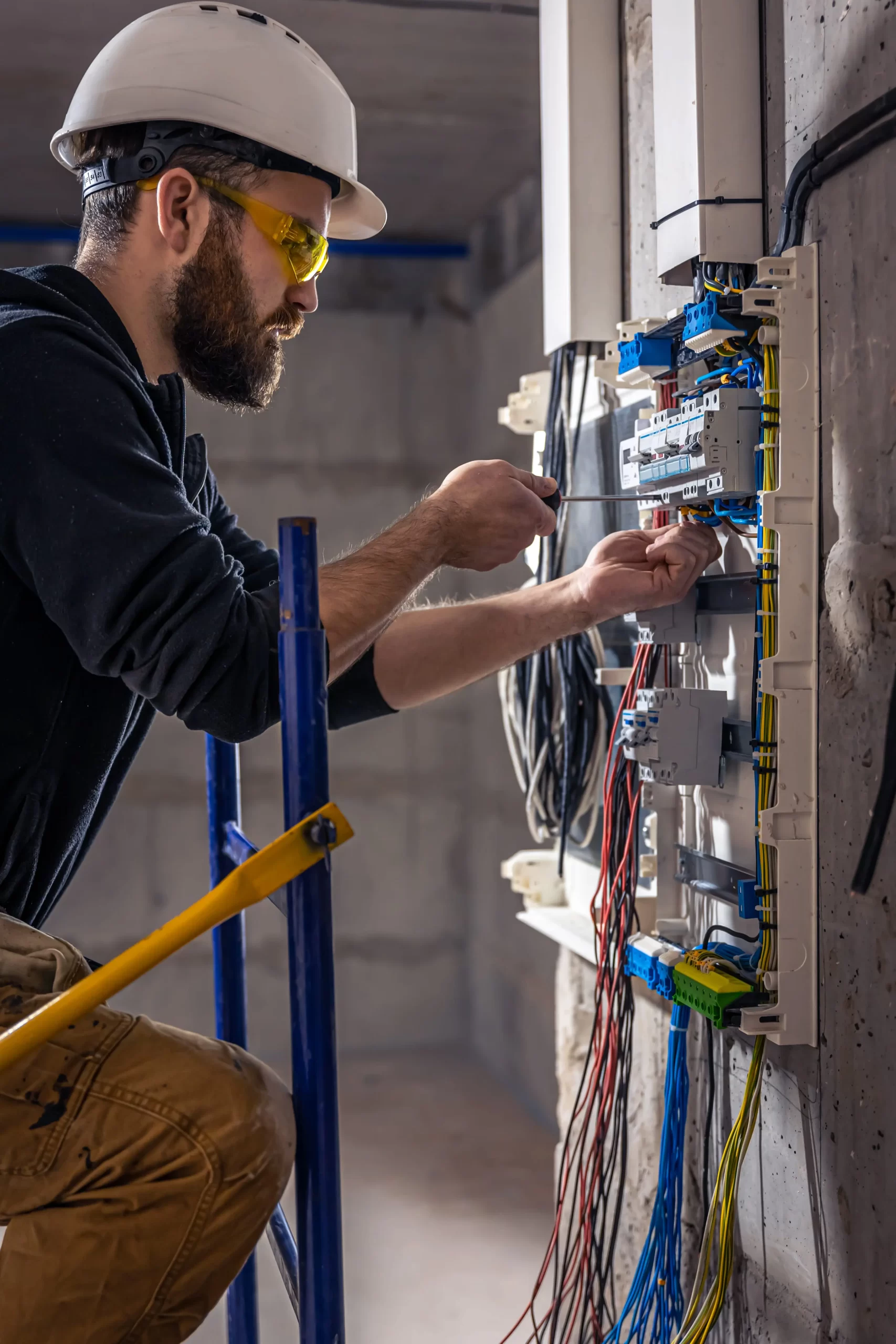 male electrician works switchboard with electrical connecting cable 2 min scaled